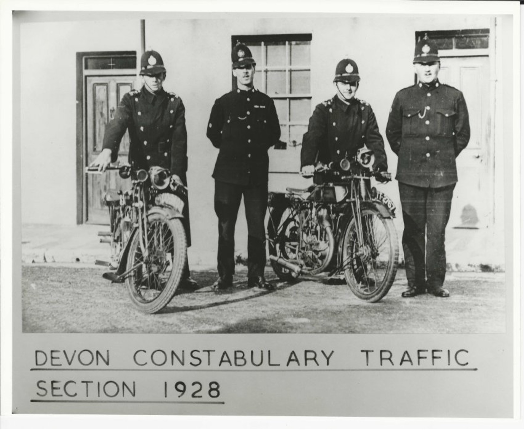 Four policemen and two motorcycles, comprising the entirety of the Devon Traffic section in 1928.